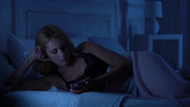 Mooie Vrouw Liggend Bed Reserveren Teleurstellend Sms Bericht Smartphone — Stockvideo