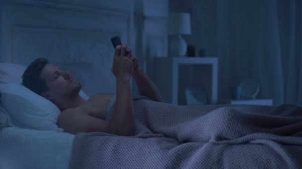 Man Liggend Bed Chatten Telefoon Afkeren Van Vrouw Verleidelijke Lingerie — Stockvideo