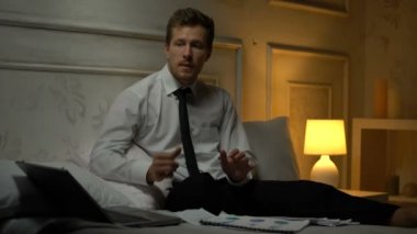 Genç işadamı hafif dans hareketleri, başarılı başlangıç yapıyor yatağa oturmuş