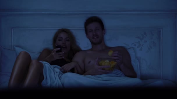 Pareja Sentada Cama Seleccionando Programa Televisión Para Ver Comiendo Bocadillos — Vídeo de stock