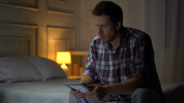 不快乐的孤独的年轻男性坐在床上看照片 失踪的妻子 — 图库视频影像