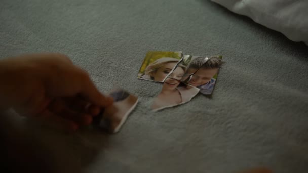 年轻男性的手试图与女友拼凑部分撕破的照片 — 图库视频影像