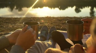 Çay bardak tungur ve güzel günbatımı, zevk göl kenarında oturan çift sakin ol