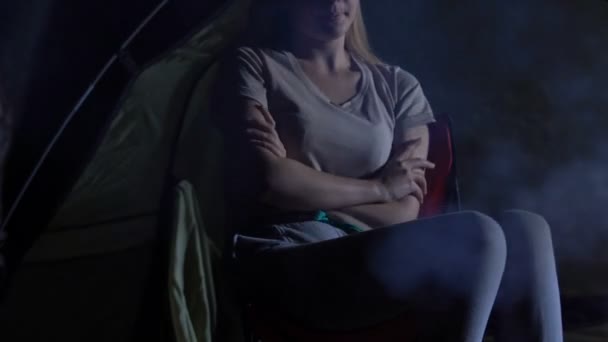 キャンプの火のそばに座っている冷凍の女性にウールの毛布を取って思いやりのある彼氏 — ストック動画