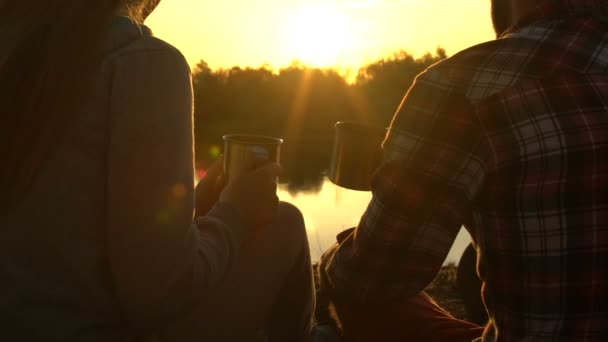 親友の話と森の湖 キャンプのそばに座って 夕日に紅茶を飲む — ストック動画