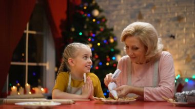 Neşeli büyükanne ve Noel partisi için çerezleri dekorasyon kız mutlu tatiller