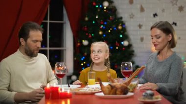 Anne ve kızı Noel öğle yemeğinde, öpüşme baba tatil eve kamera için arıyorsunuz