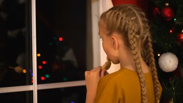 Niña Mirando Través Ventana Comiendo Galletas Esperando Los Padres Para — Vídeo de stock