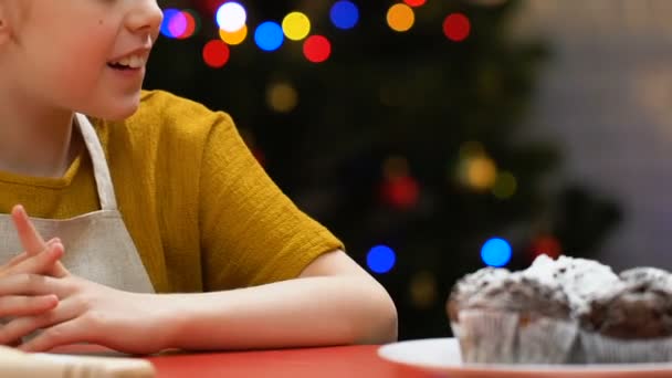 孩子在围裙偷纸杯蛋糕从节日桌上 品尝甜点 特写镜头 — 图库视频影像