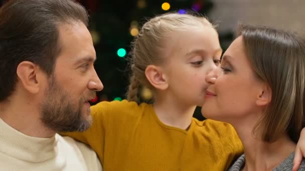 女孩亲吻爸爸妈妈在脸颊上 显示爱和关心的家庭在圣诞节 — 图库视频影像