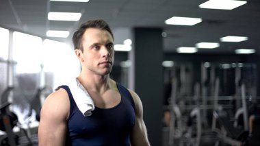 Omuz rahatlatıcı spor salonunda sert çalışmadan sonra havlu ile yorgun vücut geliştirmeci
