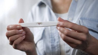 Negatif hamilelik testi elele kadın kameradan önce gösteren