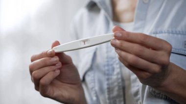 Negatif hamilelik testi tutarak ve kameraya, closeup gösterilen eller