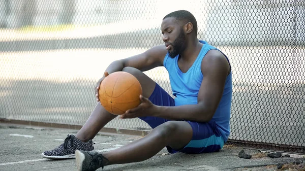 Одинокий Черный Баскетболист Сидит Стадионе Держит Мяч Спорт — стоковое фото