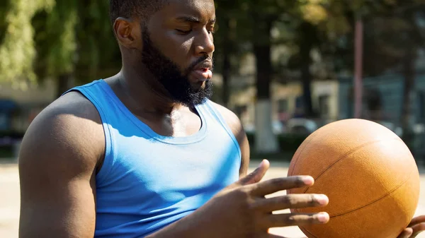 Ernstige Zwarte Man Zit Alleen Stadion Het Gooien Van Bal — Stockfoto