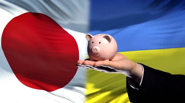 Japan Investeringar Ukraina Affärsman Hand Innehav Piggybank Flagga Bakgrund — Stockfoto