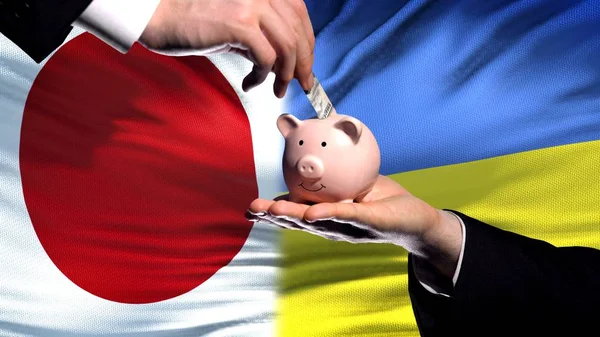 Japan Investeringar Ukraina Hand Att Lägga Pengar Piggybank Flagga Bakgrund — Stockfoto