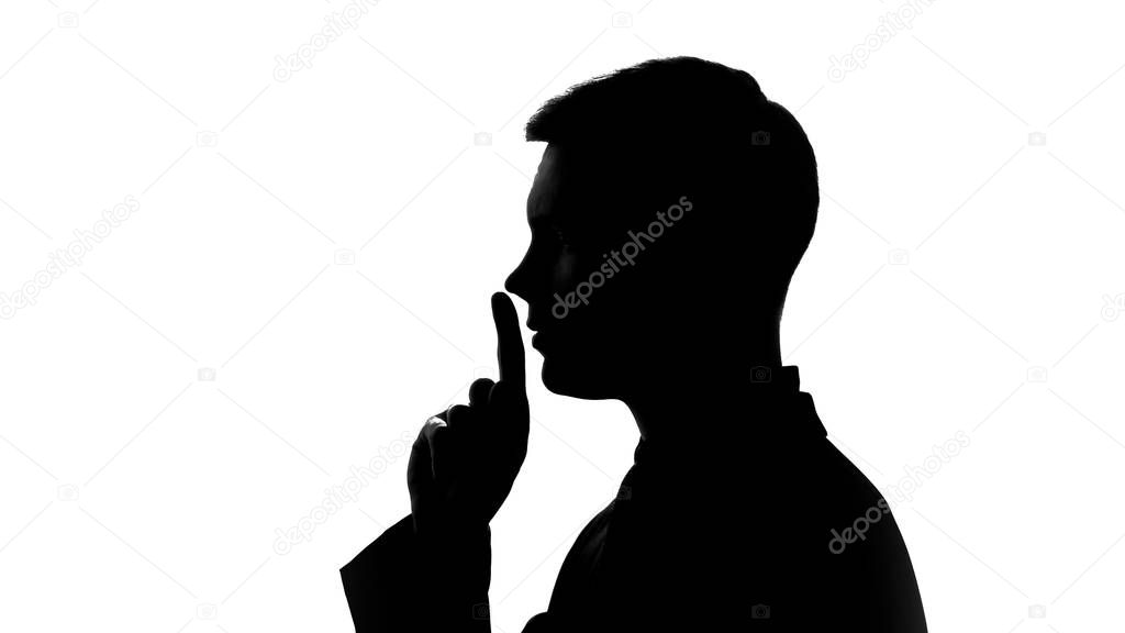 Man showing gesture of silence, non disclosure of secret data, fingers on lips