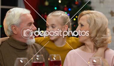 Büyükanne ve Büyükbaba şirin torunu, yaşlı çift Xmas çocuk görmekten mutlu öpüşme