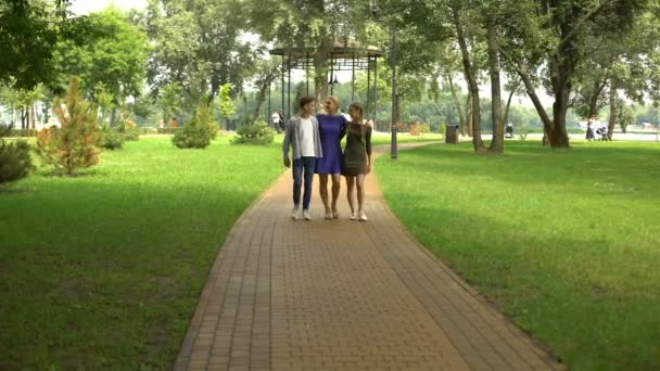 代の子供と過ごす時間を公園に沿って歩いてフレンドリーな家族 — ストック動画