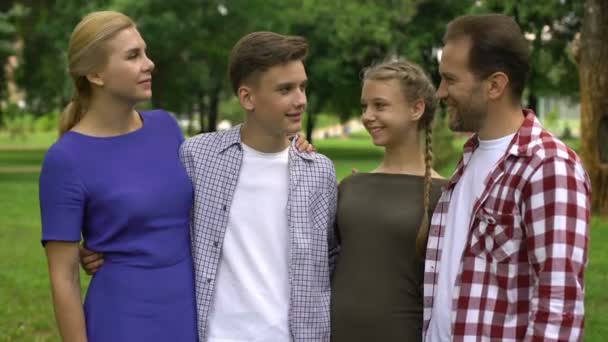 Ευτυχισμένη Οικογένεια Που Αγκαλιάζει Και Χαμογελά Στο Πάρκο Ποζάρουν Στην — Αρχείο Βίντεο