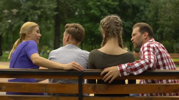 Pais Alegres Seus Filhos Adolescentes Planejando Fim Semana Banco Parque — Vídeo de Stock