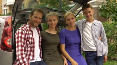 Son derece mutlu çocuklar ve araba bagajı duran, başparmak gösterilmesini ebeveynler