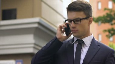 Uymak smartphone şehir sokak, karlı sözleşme üzerinde mutlu gülümseyen adam