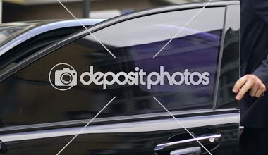 Zengin bir adam siyah şık araba, sürücü koltuğunda oturan takım elbiseli yakışıklı adam