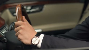Sürücü yerinde oturan ve direksiyon simidi, yeni araba satın alma tutan takım elbiseli adam