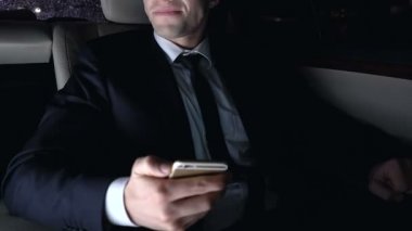 Arabanın arka koltuğunda oturan ve akıllı telefon, gece şehir kullanarak hayal kırıklığına adam