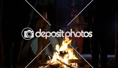 Şenlik ateşi bira şişeleri ile duruyorlar, iyi vakit geçiriyor kampçılar gülümseyen