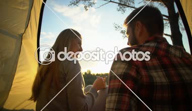 Çadırda oturan ve sıcak çikolata, açık hava sabah içme flört çift