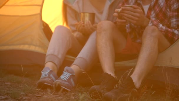 朋友穿着舒适的鞋子坐在帐篷里喝茶 在森林里徒步旅行 — 图库视频影像