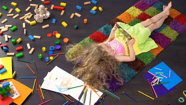 Bionda Bambina Con Capelli Biondi Sdraiata Tappeto Colorato Giocare Tablet — Foto Stock