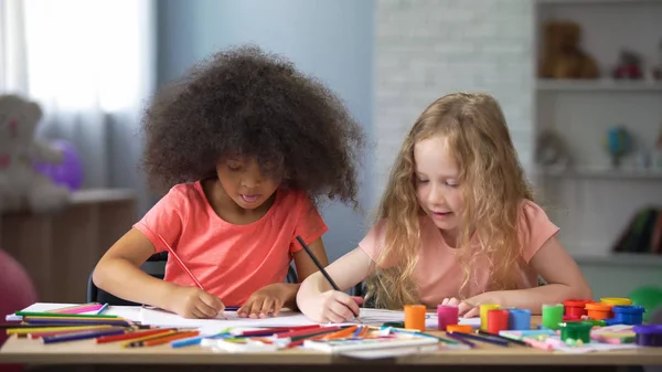 Dwie Dziewczynki Wieloetnicznej Rysunek Przy Stole Kolorowe Ołówki Szczęśliwe Dzieciństwo — Zdjęcie stockowe