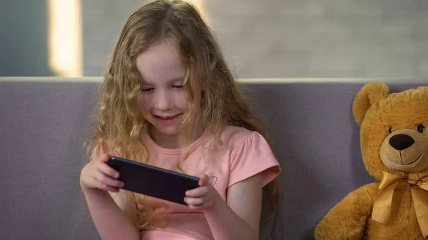 微笑的小女孩在智能手机应用程序上练习数学 早期教育软件 — 图库照片