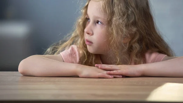 Little Blond Curly Sad Girl Sitting Table Thinking Own Behavior — Stock Photo, Image