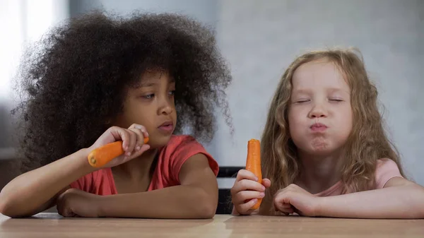 Маленькие Симпатичные Многорасовые Девочки Сидят Столом Едят Морковку Аппетитом — стоковое фото