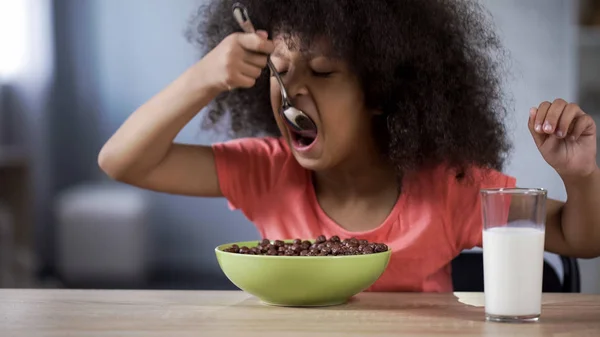 Милая Черноволосая Кудрявая Девушка Ест Шоколадные Хлопья Нездоровую Сахарную Еду — стоковое фото