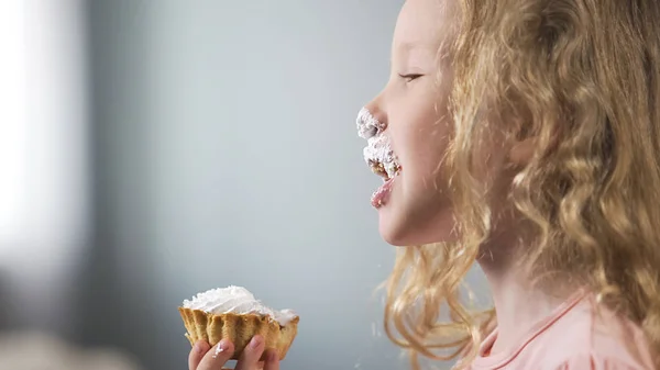 快乐的金发女孩吃奶油纸杯蛋糕在生日聚会上 快乐的微笑的孩子 — 图库照片