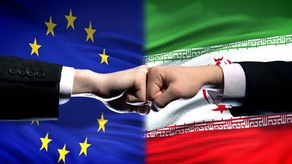 AB vs Iran çatışma, uluslararası ilişkiler kriz, yumruk bayrak arka plan üzerinde