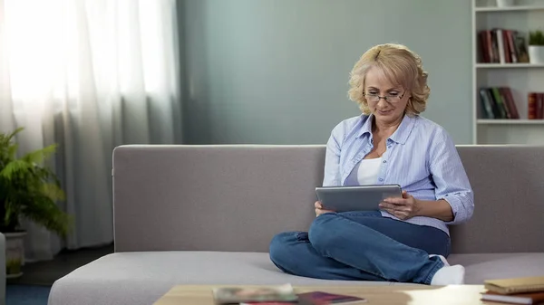 Erwachsene Frau Sitzt Auf Sofa Und Hält Tablet Und Kauft — Stockfoto