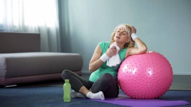 Yorgun aktif bayan ev egzersiz fitness topu ile sonra havlu ile silinerek