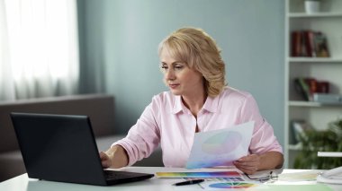 Kadın tasarımcı laptop, proje üzerinde tablo üzerinde renk düzeni seçme