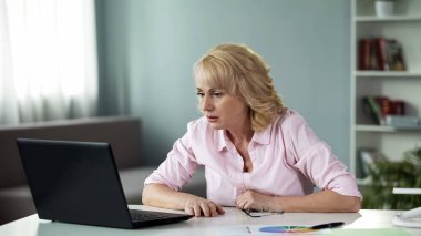 Haber okuma dizüstü evde, online video izlerken sürpriz üst düzey Bayan