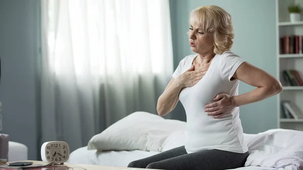 Ziemlich Reife Frau Sitzt Auf Dem Bett Und Leidet Herzinfarkt — Stockfoto