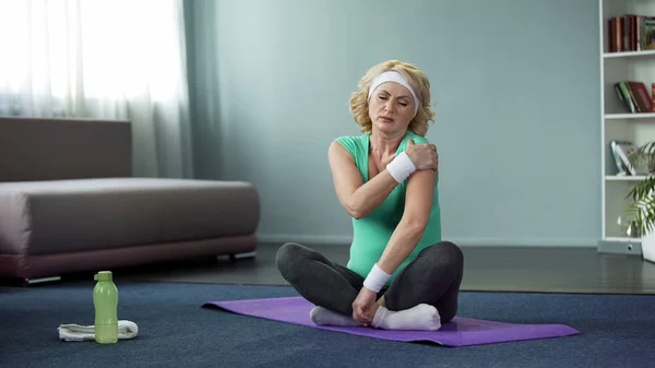 Mujer Mayor Rubia Ropa Deportiva Sentada Una Esterilla Yoga Masajeando —  Fotos de Stock