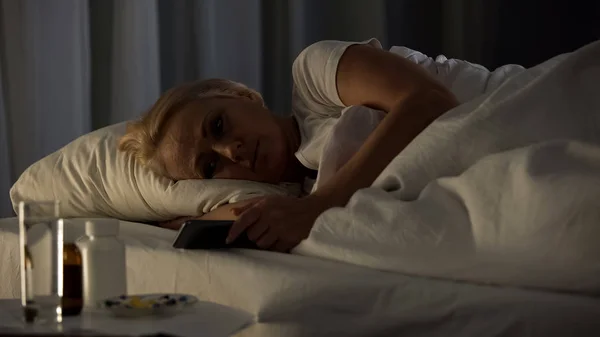 Грустная Пожилая Женщина Смотрит Телефон Лежа Кровать Ночное Одиночество Болезнь — стоковое фото