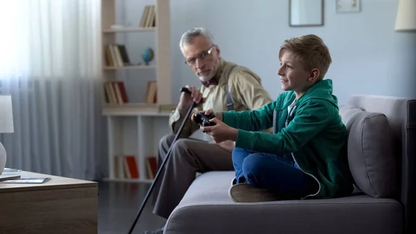 Avô Insatisfeito Olhando Para Neto Feliz Jogando Lacuna Geração Jogos — Fotografia de Stock